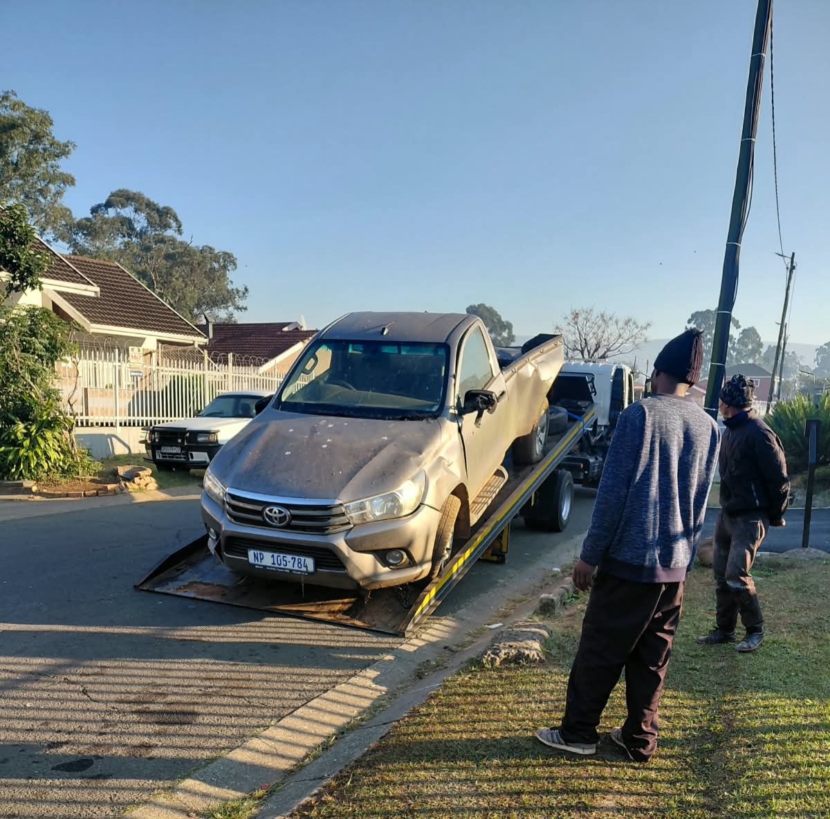 Van on a tow truck showing front-end accident damage